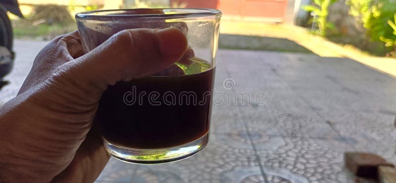 Savoring a dark morning brew outdoors. That first sip of coffee, enjoyed in the warm, bright sunlight stock images