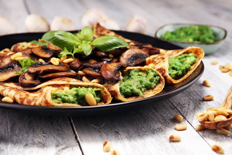 Savory Homemade Mushroom and Spinach Crepes with Cheese and avocado. stock photo Savory Homemade Mushroom and Spinach Crepes with Cheese and avocado. stock photo