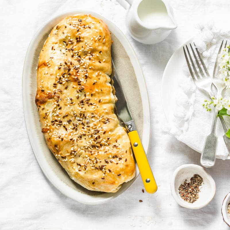 Savoury cabbage, broccoli, mushrooms and mozzarella cheese strudel served on a white table, top view. Flat lay stock images Savoury cabbage, broccoli, mushrooms and mozzarella cheese strudel served on a white table, top view. Flat lay stock images