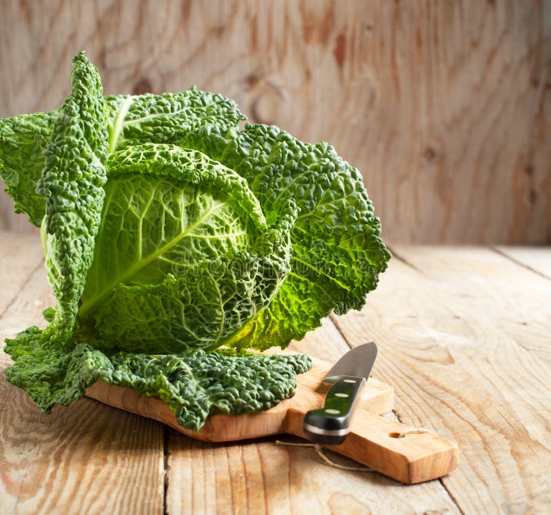 Savoy cabbage on wooden chopping board