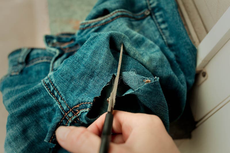 Sawing and cutting jeans. royalty free stock photography