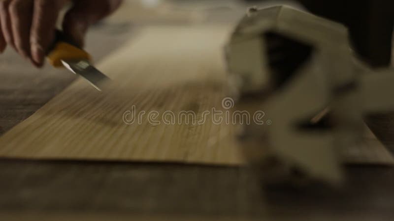 A sawmill worker cuts and sews wooden veneer, close-up, interline, industry