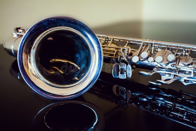 Saxophone tenor. Woodwind Classical Instrument. Jazz, blues, classics. Music. Saxophone on a black background. Black mirror surfac