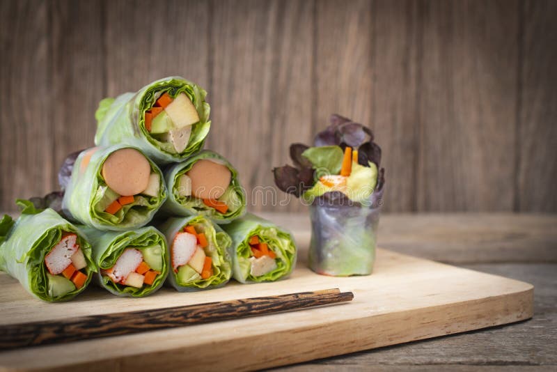 Sałatek rolki umieszczać na drewnianym stole z chopsticks umieszczającymi przed zdjęcie stock