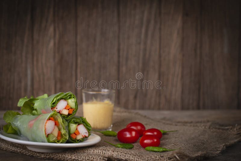 Sałatkowe rolki umieszczać obok na bielu talerzu umieszczającym na worku tam są pomidorowe, chili i sałatkowego opatrunku umieszc fotografia royalty free