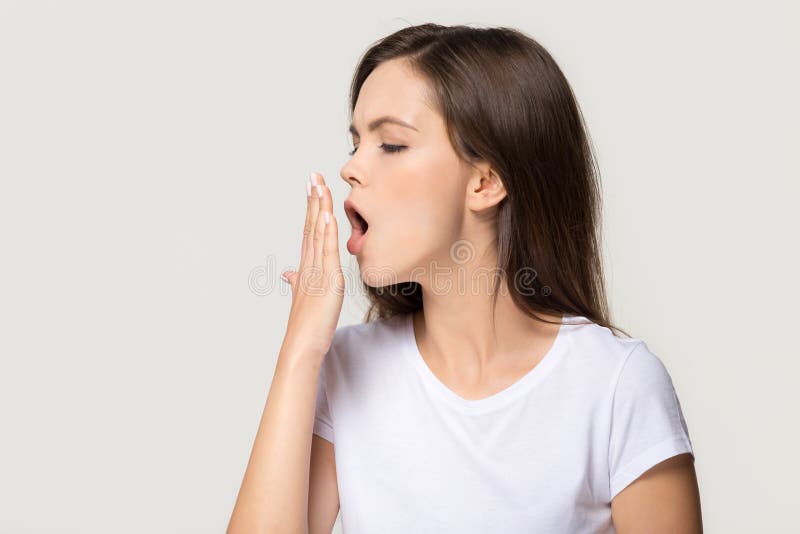 Tired funny sleepy teen girl student yawning, drowsy bored deprived young woman feeling somnolent lazy gaping suffering from lack of energy or sleep boredom isolated on grey white studio background. Tired funny sleepy teen girl student yawning, drowsy bored deprived young woman feeling somnolent lazy gaping suffering from lack of energy or sleep boredom isolated on grey white studio background