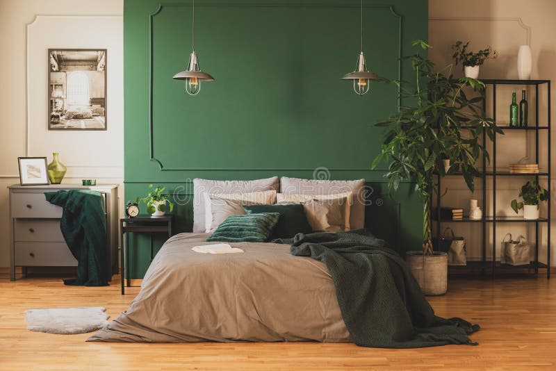 Scaffale per libri industriale e cassettone di legno in camera da letto contemporanea interna con la giungla urbana immagini stock libere da diritti
