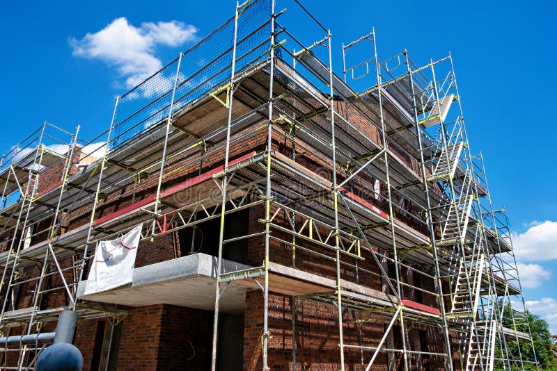 Scaffolding Near a Highrise Brick House Under Construction in Germany