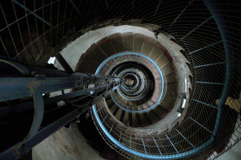 Scala a chiocciola strettamente d'avvolgimento del cemento dentro di un faro con una prospettiva blu dell'inferriata che guarda g immagine stock Scala a chiocciola strettamente d'avvolgimento del cemento dentro di un faro con una prospettiva blu dell'inferriata che guarda g immagine stock