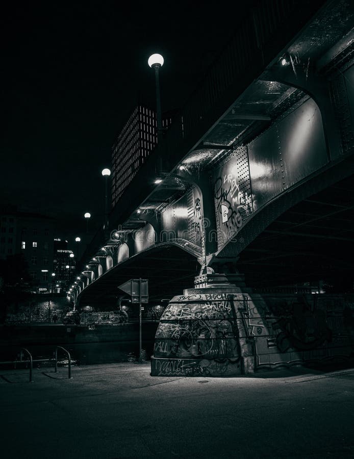 Scala di grigi ripresa in formato verticale di un ponte urbano notturno in città immagine stock libera da diritti