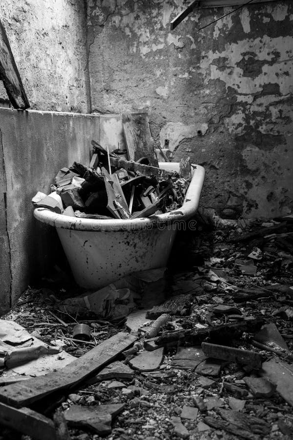 Scala di grigi verticale ripresa da un bagno rotto in una casa abbandonata fotografia stock libera da diritti