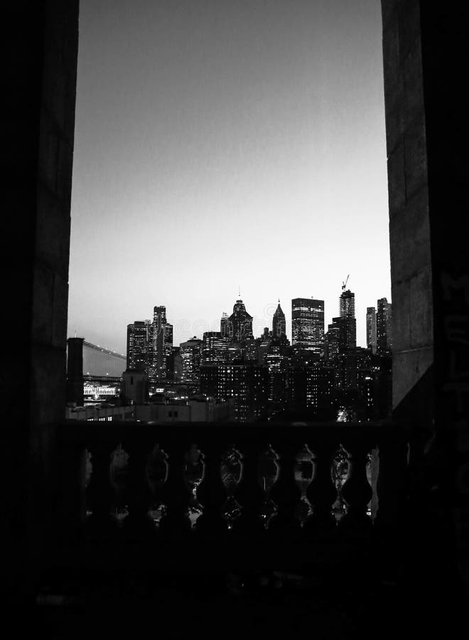 Scala di grigi verticale scattata di notte sulla skyline nyc fotografia stock