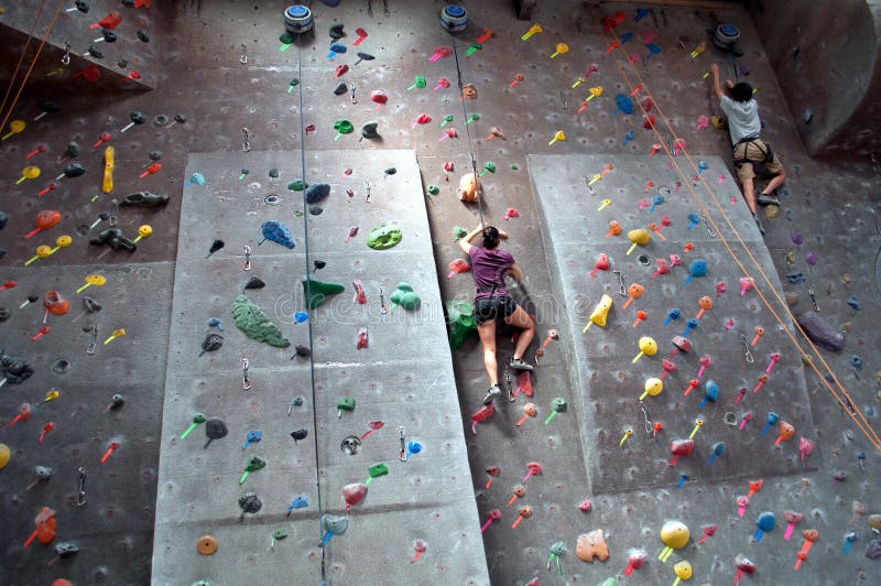 An image of people rock climbing at an indoor gym. An image of people rock climbing at an indoor gym.
