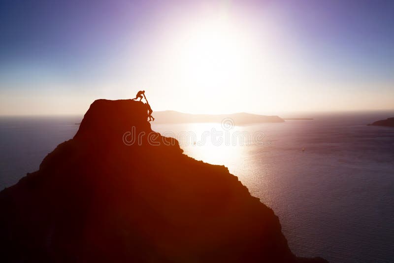 Scalatore che dà mano e che aiuta il suo amico a raggiungere la cima della montagna Aiuto, supporto fotografia stock Scalatore che dà mano e che aiuta il suo amico a raggiungere la cima della montagna Aiuto, supporto fotografia stock