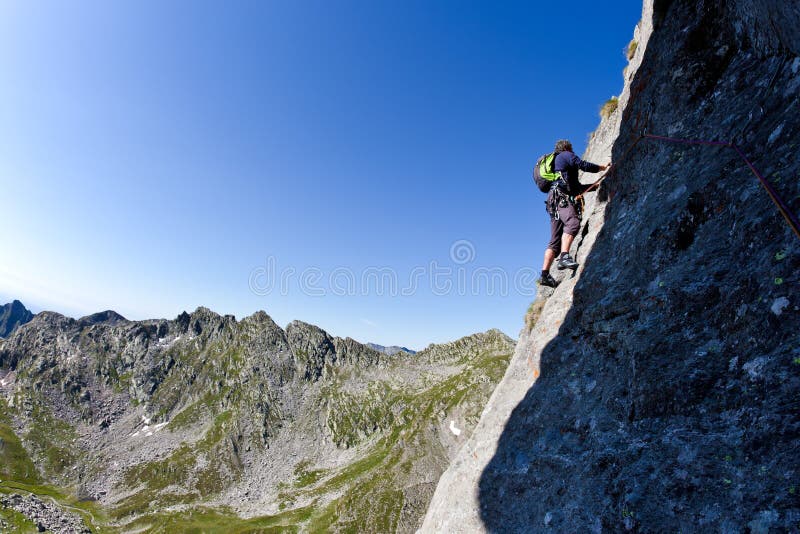 Scalatore maschio caucasico che arrampica una parete ripida fotografia stock