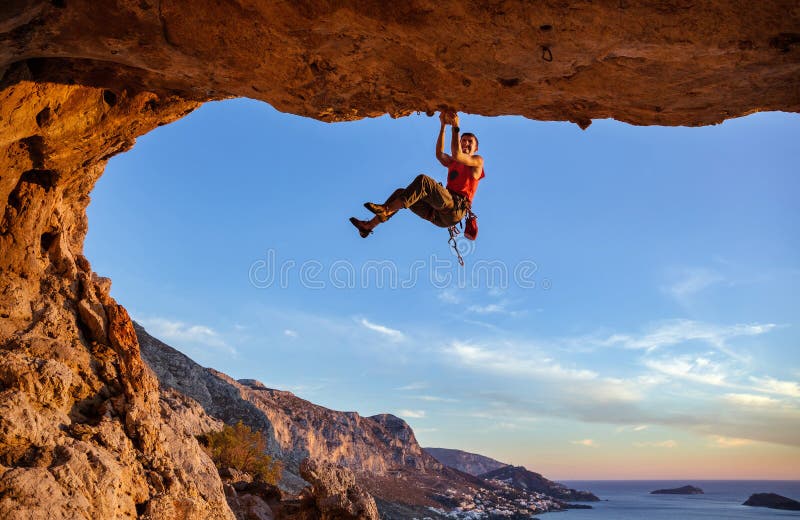 Scalatore maschio che afferra sulla maniglia mentre scalando in caverna immagini stock libere da diritti