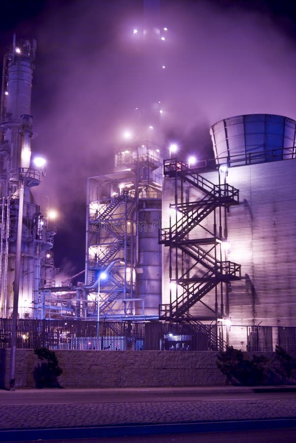 An oil refinery in the United States with a series of foggy and smoky stacks. Industrial complex and stairs leading up into the smoke stacks. An oil refinery in the United States with a series of foggy and smoky stacks. Industrial complex and stairs leading up into the smoke stacks.