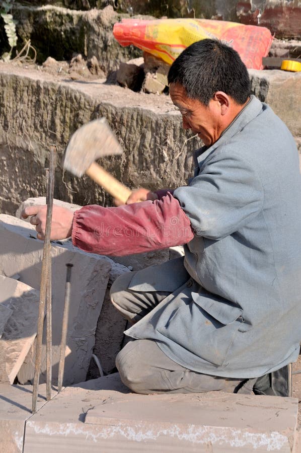 Scalpellino in Cina. Lo scalpellino sta tagliando la pietra in moda da poterla usare per aprire la strada.