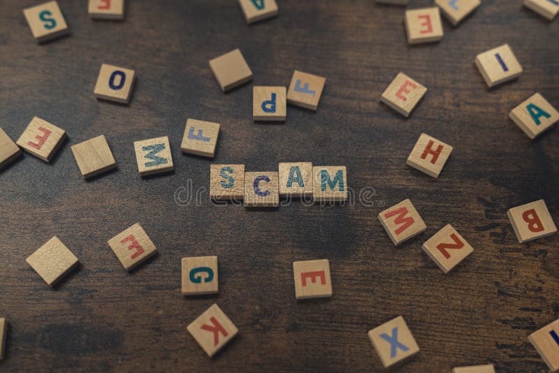 SCAM - scattered square colourful letter puzzles creating a word. The danger of being scammed and tricked by criminals.