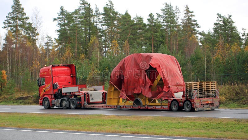 PAIMIO, FINLAND - OCTOBER 23, 2015: Scania R730 truck hauls industrial object covered with tarpaulin as exceptional load. Abnormal transport permit is required, if any dimension of the transport exceeds the free dimension limits. PAIMIO, FINLAND - OCTOBER 23, 2015: Scania R730 truck hauls industrial object covered with tarpaulin as exceptional load. Abnormal transport permit is required, if any dimension of the transport exceeds the free dimension limits.