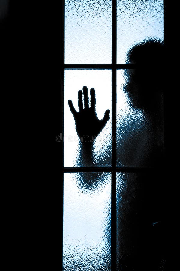 Scared boy behind glass door stock photos