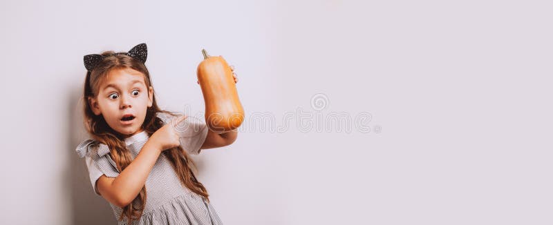 Scared little girl holding decorative pumpkins on white background royalty free stock photo Scared little girl holding decorative pumpkins on white background royalty free stock photo