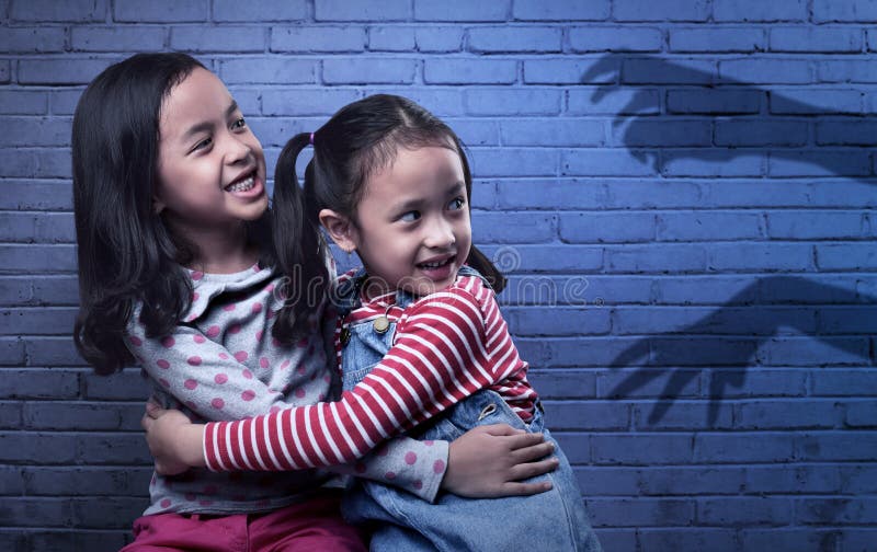 Scared two asian little girl looking at black ghost hand royalty free stock photos Scared two asian little girl looking at black ghost hand royalty free stock photos