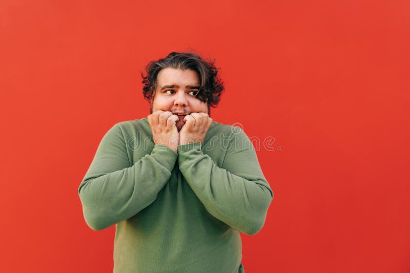 Scared Young Overweight Hispanic Guy with a Stylish Haircut is Standing