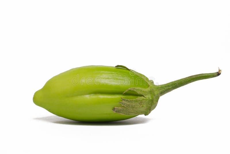 Lot of lot of vibrant green scarlet eggplant vegetable on top of each other  against a black background. Graphic minimalist image of food. Stock Photo