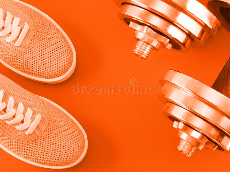 Scarpe da tennis arancio luminose su fondo arancio con le teste di legno immagini stock libere da diritti Scarpe da tennis arancio luminose su fondo arancio con le teste di legno immagini stock libere da diritti
