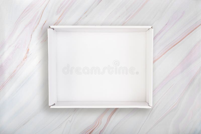 Scatola aperta bianca su fondo di marmo Scatola di cartone bianca in bianco su struttura di marmo con il modello naturale fotografia stock libera da diritti Scatola aperta bianca su fondo di marmo Scatola di cartone bianca in bianco su struttura di marmo con il modello naturale fotografia stock libera da diritti