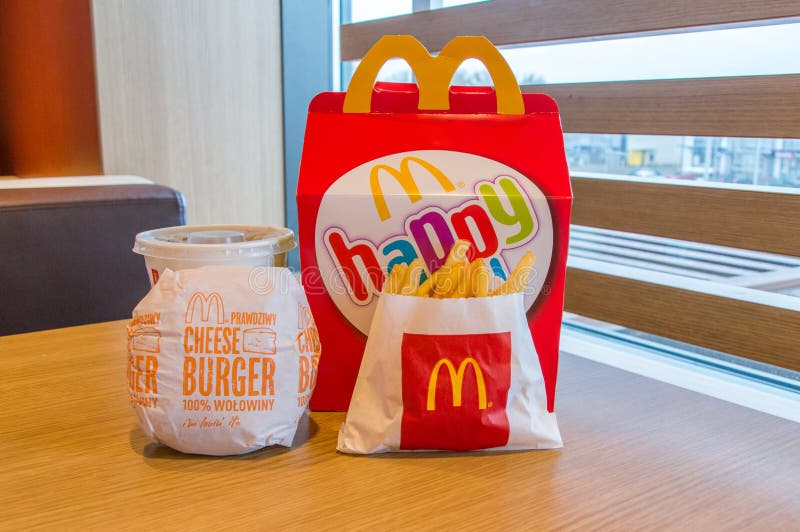 Scatola felice del pasto di Mcdonalds con Coca-Cola, le patate fritte ed il cheeseburger sulla tavola di legno immagini stock libere da diritti Scatola felice del pasto di Mcdonalds con Coca-Cola, le patate fritte ed il cheeseburger sulla tavola di legno immagini stock libere da diritti