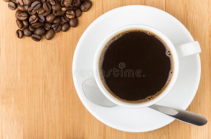 Scattered coffee beans and glass cup