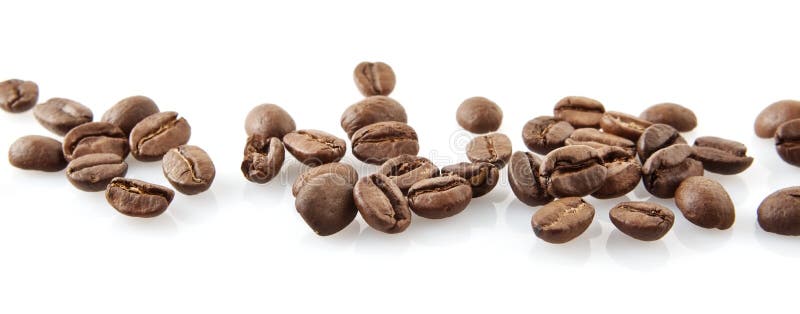 Scattered coffee beans in line on white