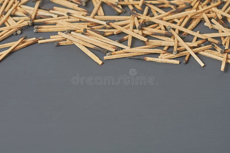 Scattered many used matchsticks with burnt sulfur on dark concrete table on kitchen