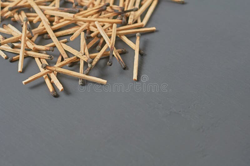 Scattered many used matchsticks with burnt sulfur on dark concrete table on kitchen