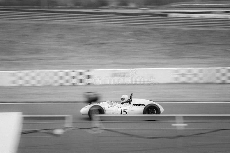 Scatto in scala di grigi di un'auto tradizionale che corre in un circuito. fotografia stock libera da diritti