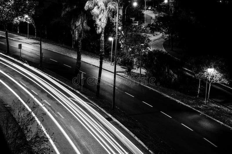 Scatto in scala di grigi di una strada vuota durante la notte immagini stock