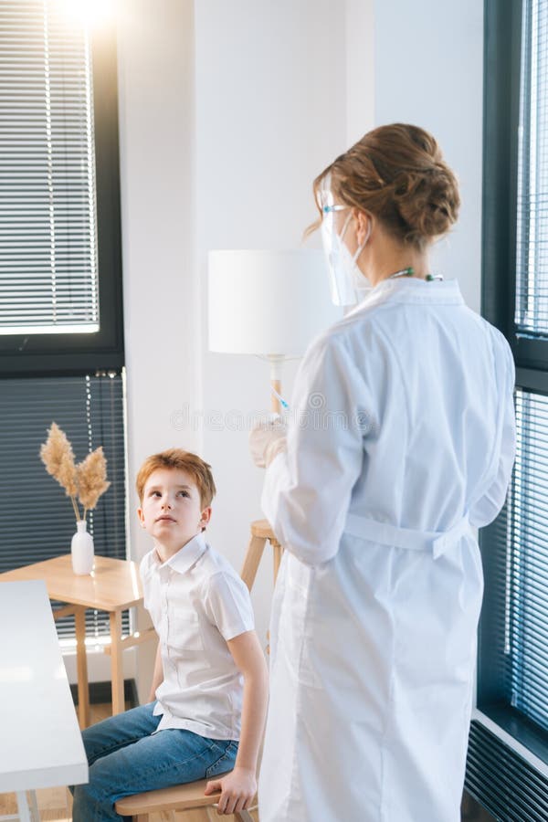 Scatto verticale di una donna dottoressa non riconoscibile in guanti di lattice che preparano il vaccino per un bambino all'ospeda immagini stock libere da diritti