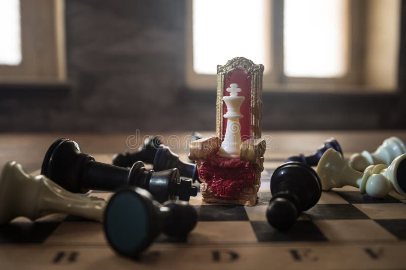 Scaun regal roșu în miniatură pe masă din lemn. Tronul Medieval pe tabla de șah. Conceptul de joc de șah la bord al ideilor de afa royalty free stock images