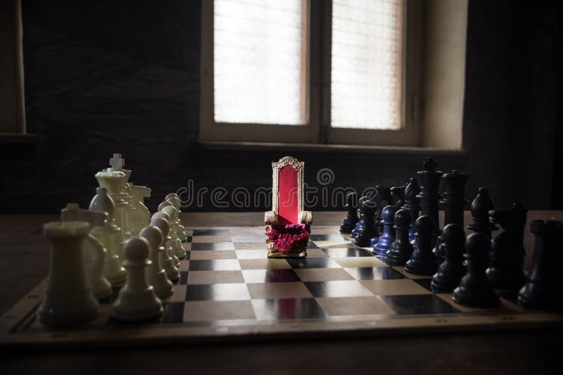 Scaun regal roșu în miniatură pe masă din lemn. Tronul Medieval pe tabla de șah. Conceptul de joc de șah la bord al ideilor de afa stock image