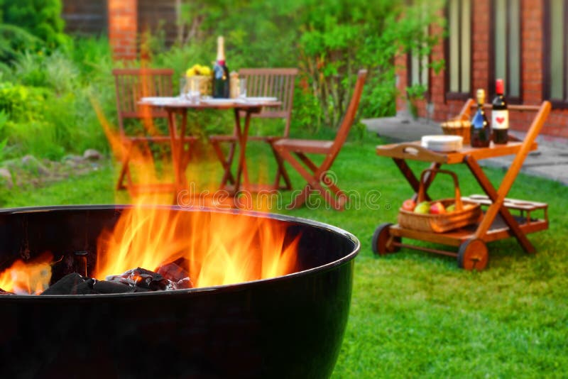 Scena del BBQ di fine settimana di estate con la griglia sul giardino del cortile immagine stock libera da diritti Scena del BBQ di fine settimana di estate con la griglia sul giardino del cortile immagine stock libera da diritti