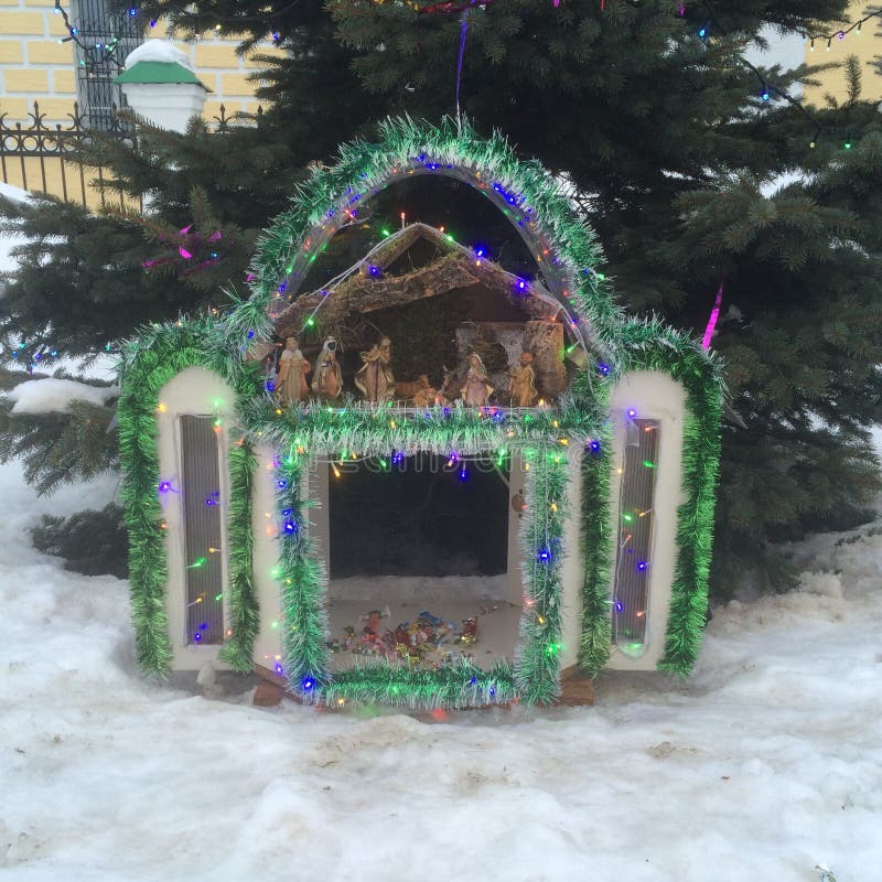 Decorative Christmas nativity scene outdoors with snow and a tree in the background. Decorative Christmas nativity scene outdoors with snow and a tree in the background.