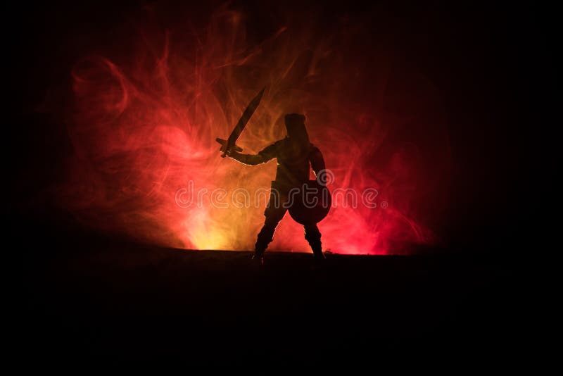 Scena medievală a bătăliei. siluete de figuri, ca obiecte separate, se luptă între războinici pe fundalul albastru închis, focar. stock photography