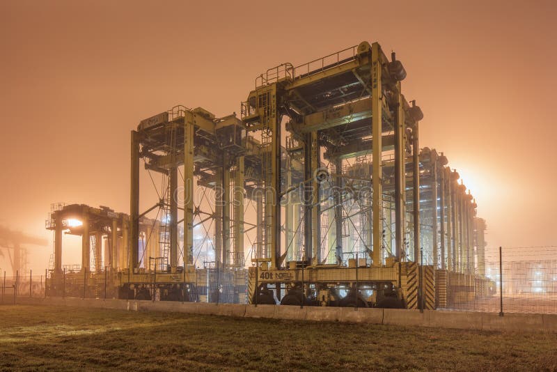 Scena nebbiosa con attrezzatura pesante nel terminale del container fotografia stock libera da diritti