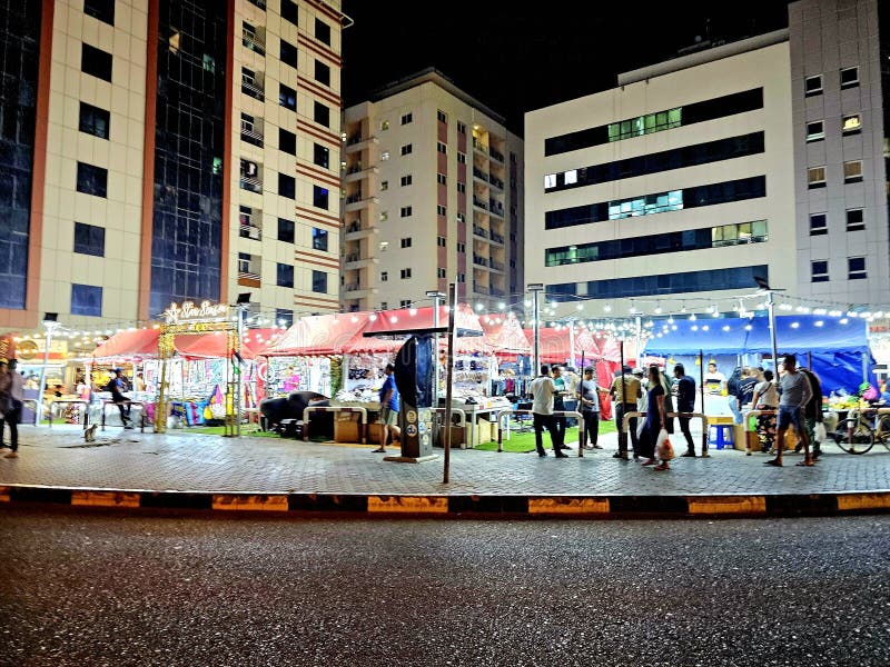 Scene di mercato notturno con diverse persone che esaltano i loro edifici e le loro case con una luce artificiale. evoca la vita n immagine stock