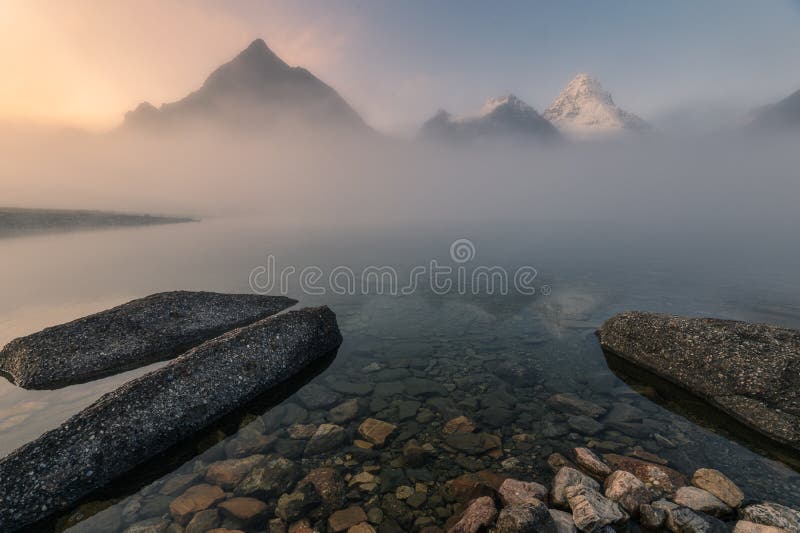 Scenery of mount Assiniboine in foggy on Magog lake at the morning