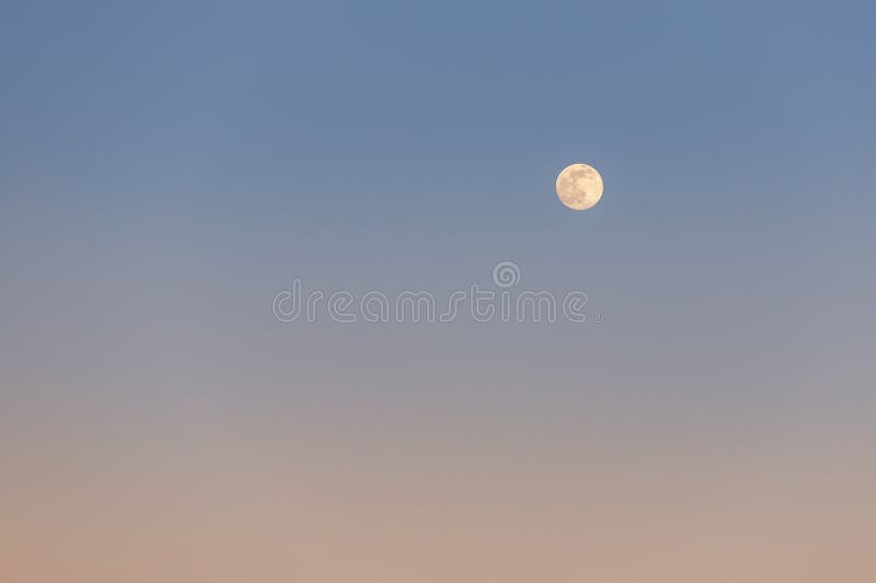 Scenic beautiful abstract full moon against clear blue to orange warm cold sunset or sunrise sky pastel background