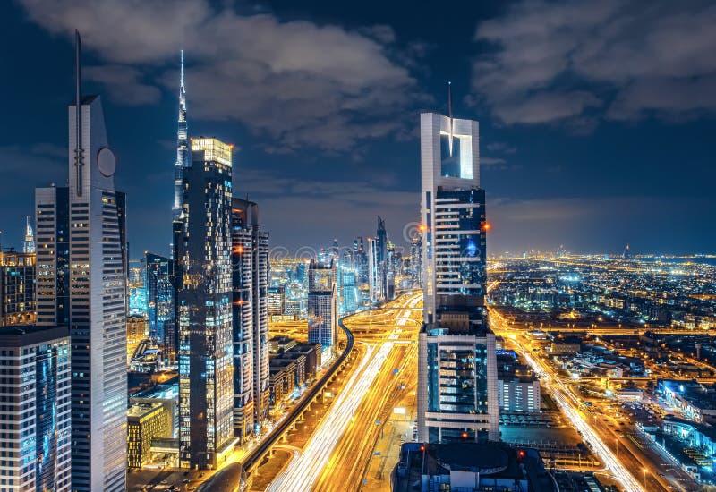 Scenic Dubai downtown skyline. Nighttime cityscape with illuminated skyscrapers and highway