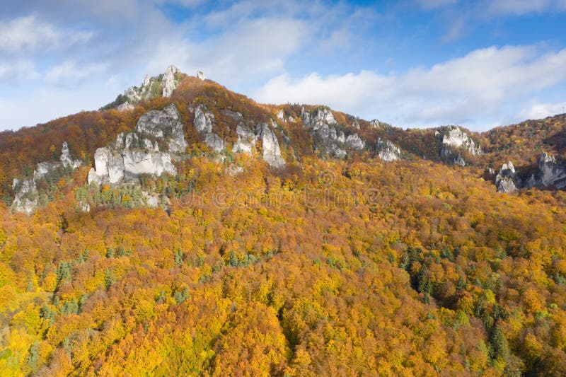 Scenic landscape in Sulov, Slovakia, on beautiful autumn sunrise with colorful leaves on trees in forest and bizarre pointy rocks